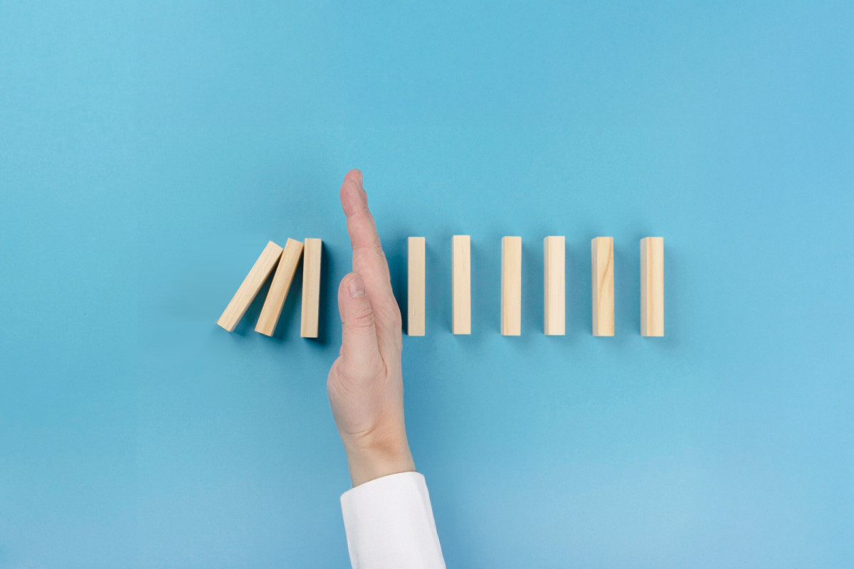 Main arrêtant des dominos