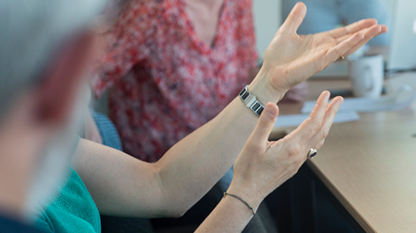 personnne parlant avec les mains dans une réunion