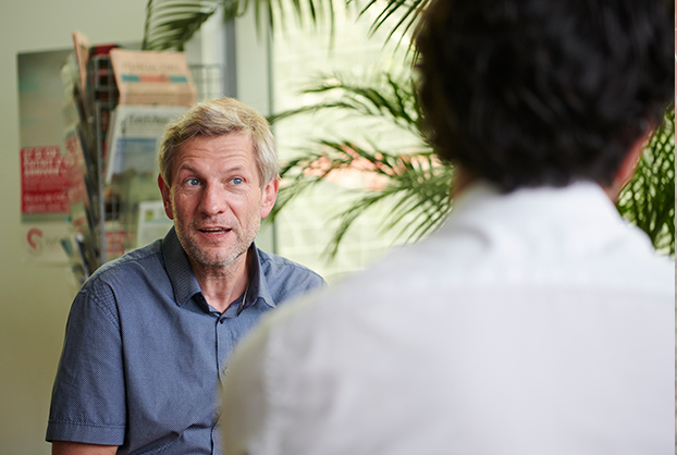 Deux experts Syndex échangeant, l'un de face, l'autre de dos