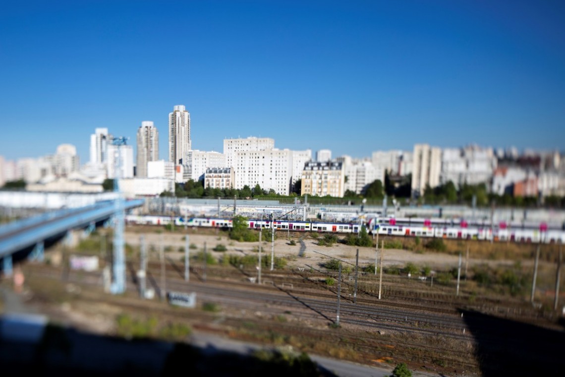 Ligne de train avec des logements sociaux en arrière plan