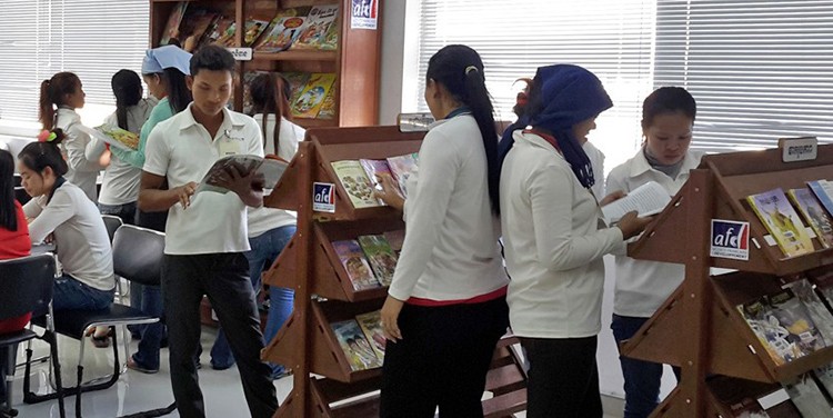 Des ouvriers cambodgiens consultent le centre de ressources en usine