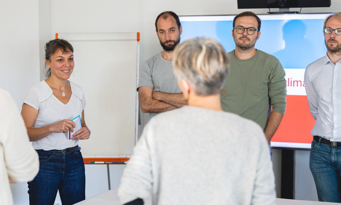 un groupe de personne debout devant un paper-board lors d'un atelier de formation