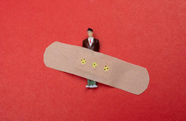 figurine sur fond rouge, avec un sparadrap